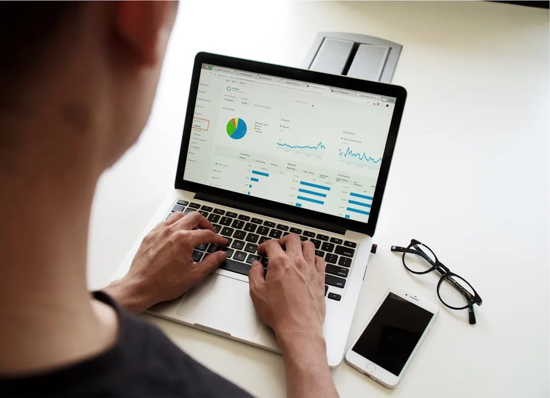 Profissional analisando dados e gráficos estratégicos em notebook durante planejamento de decisão