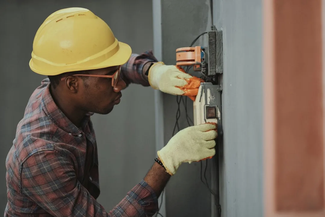 Técnico eletricista instalando fiação elétrica com capacete de segurança